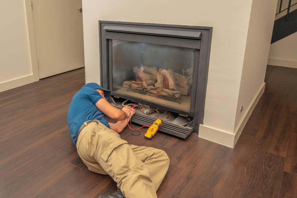 Repair man working on fireplace electronics